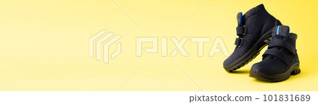 Dark blue autumn men's children's boots on a yellow background. Copy space. Banner Dark blue autumn men's children's boots on a yellow background. Copy space. Banner 101831689