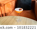 Summer cocktail garnished with dried apple slices. Orange cold beverage on bar terrace. 101832221
