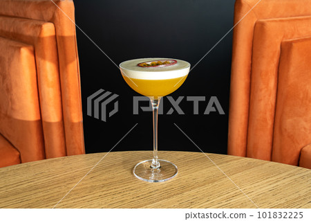 Summer cocktail garnished with passion fruit. rich yellow cold beverage on bar terrace. Summer cocktail garnished with passion fruit. rich yellow cold beverage on bar terrace. 101832225