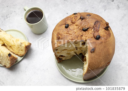 Panettone Italian Sweet Bread, Cut Piece Of Cake And Cup Of Coffee On Table And Cut Piece. Sweet bread, Fruitcake Originally From Italy, Milan Baked Dessert. Closeup. Horizontal plane 101835879