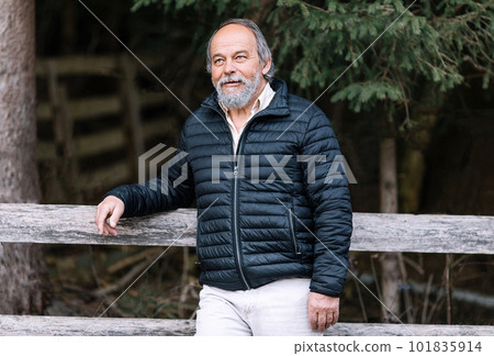Portrait of a smiling, confident, handsome, mature man during his walk in the park Portrait of a smiling, confident, handsome, mature man during his walk in the park 101835914