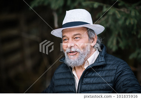 Portrait of a smiling, confident, handsome, mature man during his walk in the park Portrait of a smiling, confident, handsome, mature man during his walk in the park 101835916