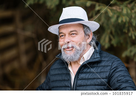 Portrait of a smiling, confident, handsome, mature man during his walk in the park Portrait of a smiling, confident, handsome, mature man during his walk in the park 101835917