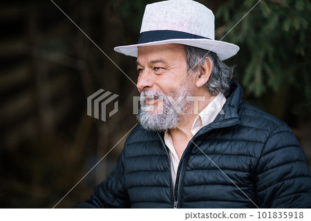 Portrait of a smiling, confident, handsome, mature man during his walk in the park Portrait of a smiling, confident, handsome, mature man during his walk in the park 101835918