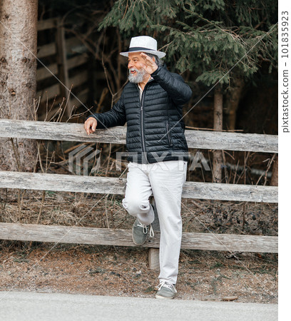 Portrait of a smiling, confident, handsome, mature man during his walk in the park Portrait of a smiling, confident, handsome, mature man during his walk in the park 101835923