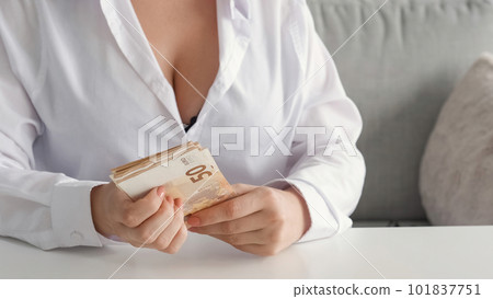 Cash savings. Home budget. Earnings income. Unrecognizable rich woman with big breasts holding money 50 bill Euro banknotes on couch. Cash savings. Home budget. Earnings income. Unrecognizable rich woman with big breasts holding money 50 bill Euro banknotes on couch. 101837751