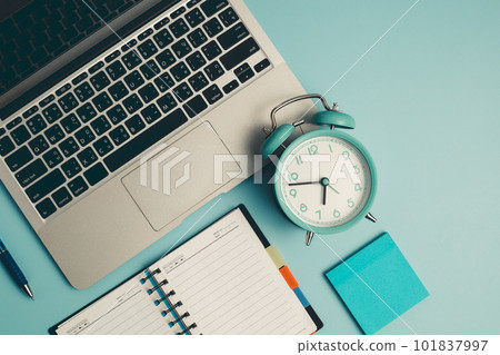 Laptop with an alarm clock, a diary notebook and others work and educational materials 101837997