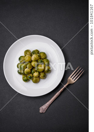Delicious boiled Brussels sprouts on a ceramic plate on a dark concrete background Delicious boiled Brussels sprouts on a ceramic plate on a dark concrete background 101841167