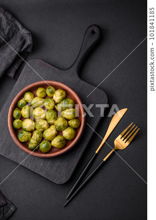 Delicious boiled Brussels sprouts on a ceramic plate on a dark concrete background 101841185