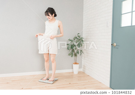 Slim Asian woman on a weight scale (diet/slimming image) 101844832