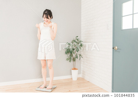 Slim Asian woman on a weight scale (diet/slimming image) 101844835