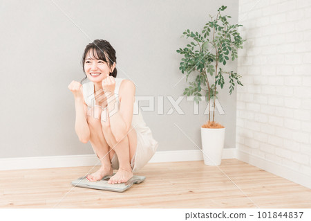 Slim Asian woman on a weight scale (diet/slimming image) 101844837