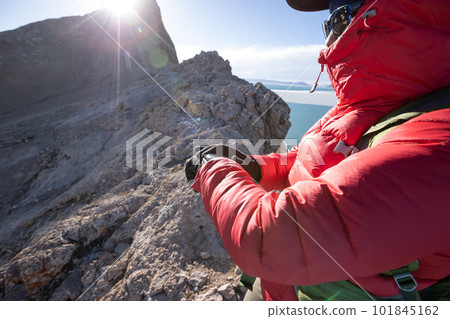 Hiker on high altitude mountain top checking the altimeter on the sports watch 101845162