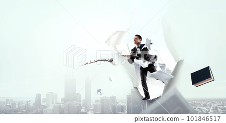 The business man is running with his notebook through paper hole The business man is running with his notebook through paper hole 101846517