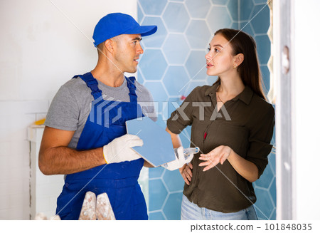 Tile setter discussing works in bathroom with woman Tile setter discussing works in bathroom with woman 101848035