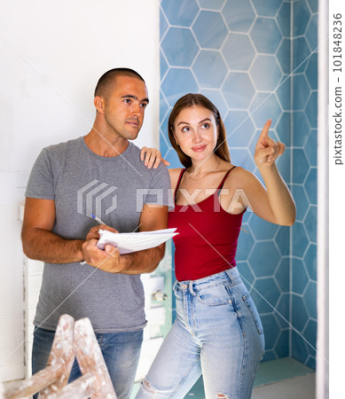 Couple planning repair works in bathroom Couple planning repair works in bathroom 101848236