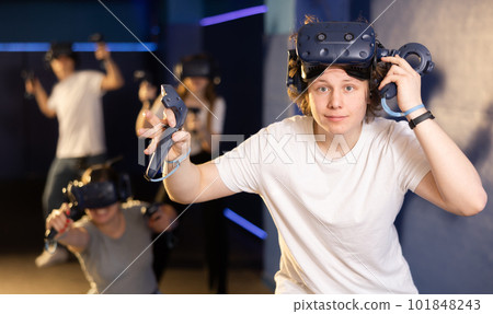 Excited young guy in VR glasses playing virtual reality game 101848243