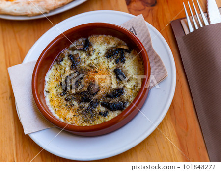 Baked provolone cheese with champignon mushrooms in clay bowl 101848272