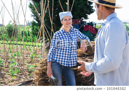 Female gardener friendly talking to neighbour on farm backyard 101848382