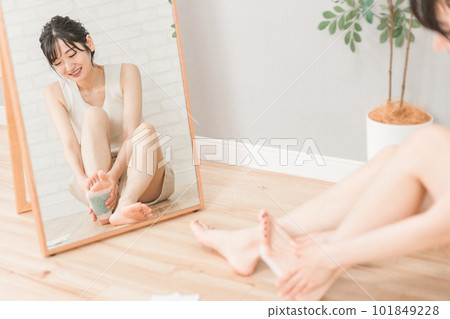 一位面帶微笑的亞洲女性,她在腿上放了一張鞋底樹片以防止腫脹(足部護理) 一位面帶微笑的亞洲女性,她在腿上放了一張鞋底樹片以防止腫脹(足部護理) 101849228