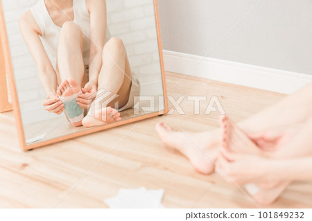 A smiling Asian woman who puts a sole tree sheet on her legs to prevent swelling (foot care) A smiling Asian woman who puts a sole tree sheet on her legs to prevent swelling (foot care) 101849232