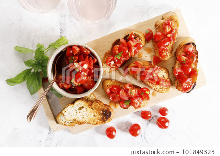 Tomato bruschetta with chopped tomatoes, garlic and herbs on toasted bread. Tomato bruschetta with chopped tomatoes, garlic and herbs on toasted bread. 101849323