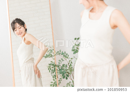 微笑的亞洲女人在鏡子裡檢查她的臀部（臀部向上） 101850953