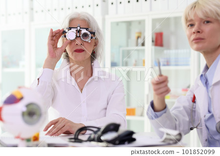 Mature woman checks eyesight looking through goggles 101852099