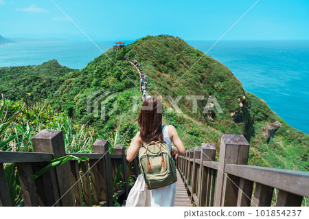 woman traveler visiting in Taiwan, Tourist with backpack sightseeing in Bitou Cape Hiking Trail, New Taipei City. landmark and popular attractions near Taipei. Asia Travel concept 101854237