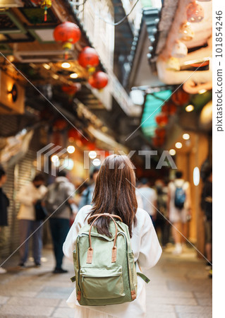 woman traveler visiting in Taiwan, Tourist with hat and backpack sightseeing and shopping in Jiufen Old Street market. landmark and popular attractions near Taipei city. Travel and Vacation concept 101854246