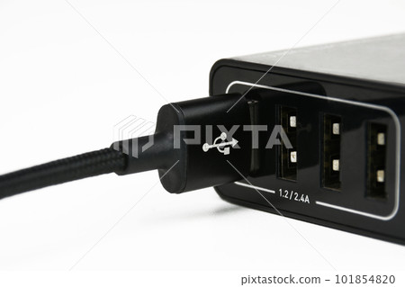 USB A charging cable in mobile phone charger port on white background USB A charging cable in mobile phone charger port on white background 101854820