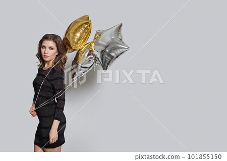 Young woman holding balloon on grey banner background with copy space Young woman holding balloon on grey banner background with copy space 101855150