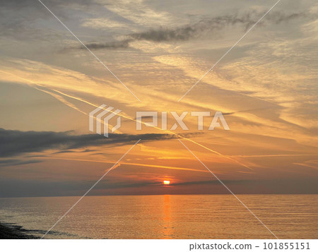Stunning landscape of deep sunset over calm smooth sea with vibrant colors Stunning landscape of deep sunset over calm smooth sea with vibrant colors 101855151