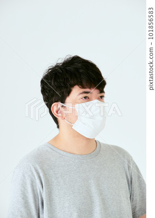 The upper body of a Japanese man in his 30s wearing a mask on a white background and looking to the left The upper body of a Japanese man in his 30s wearing a mask on a white background and looking to the left 101856583