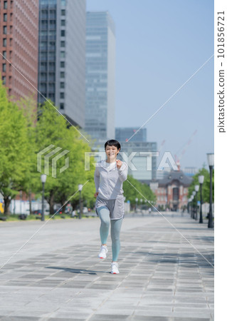 中年婦女在辦公區公園慢跑垂直姿勢 中年婦女在辦公區公園慢跑垂直姿勢 101856721
