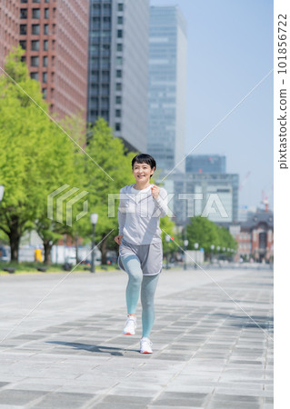 中年婦女在辦公區公園慢跑垂直姿勢 中年婦女在辦公區公園慢跑垂直姿勢 101856722