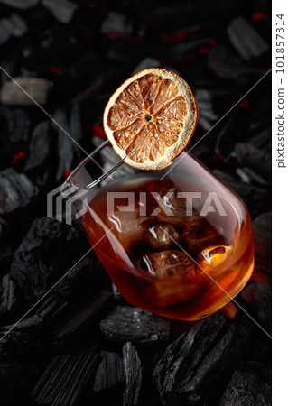 Cocktail with ice and dried orange slice. 101857314