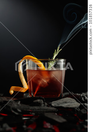 Old-fashioned cocktail  with a burning twig of rosemary. 101857316