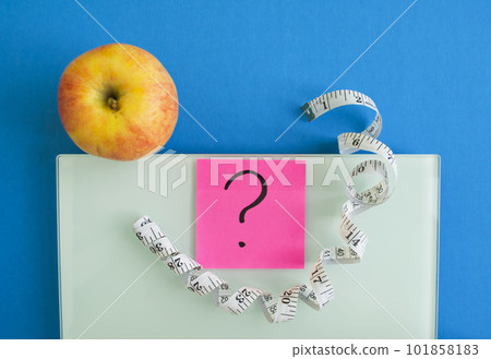 Electronic scales, a sticker with a question mark, an apple and a centimeter tape Electronic scales, a sticker with a question mark, an apple and a centimeter tape 101858183