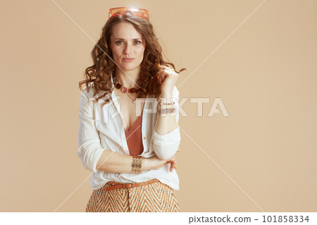 smiling woman in blouse and shorts on beige 101858334