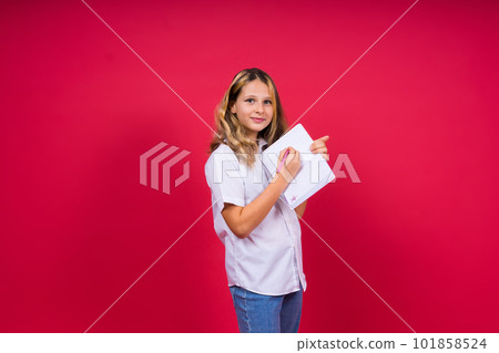 Portrait of positive little girl with notebook, looks smiling at camera, child doing homework 101858524
