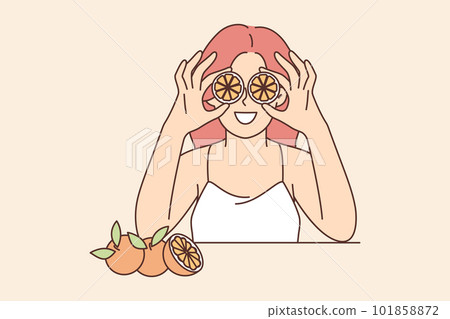 Woman holds slices of citrus fruit near eyes offering to use orange for rejuvenating facial mask 101858872