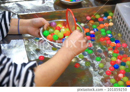 A girl scooping a ball at a stall A girl scooping a ball at a stall 101859250