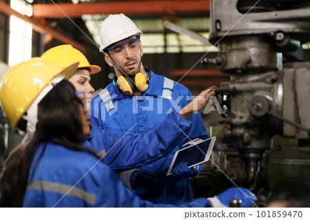 Team of mechanical engineer working together in the factory, engineers inspecting a metal machine system the factory. Female and male mechanical technician fixing a machines. 101859470