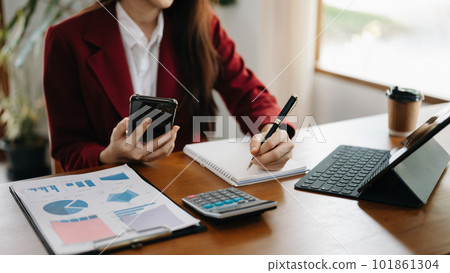Women counting coins on calculator taking from the piggy bank. hand holding pen working on calculator to calculate on desk about cost at home office.. Women counting coins on calculator taking from the piggy bank. hand holding pen working on calculator to calculate on desk about cost at home office.. 101861304