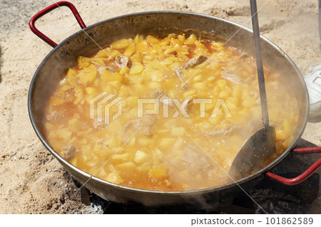 Stews. Food on fire. Preparation of food on embers of fire and firewood. Meat. Photography. Celebration in a town in the Community of Madrid, in Spain. Stews. Food on fire. Preparation of food on embers of fire and firewood. Meat. Photography. Celebration in a town in the Community of Madrid, in Spain. 101862589