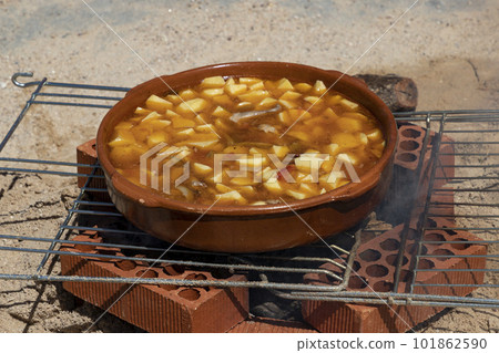 Stews. Food on fire. Preparation of food on embers of fire and firewood. Meat. Photography. Celebration in a town in the Community of Madrid, in Spain. Stews. Food on fire. Preparation of food on embers of fire and firewood. Meat. Photography. Celebration in a town in the Community of Madrid, in Spain. 101862590