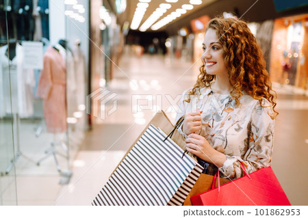 Fashionable woman with multi-colored bags in modern shop center. The joy of consumption. Fashionable woman with multi-colored bags in modern shop center. The joy of consumption. 101862953