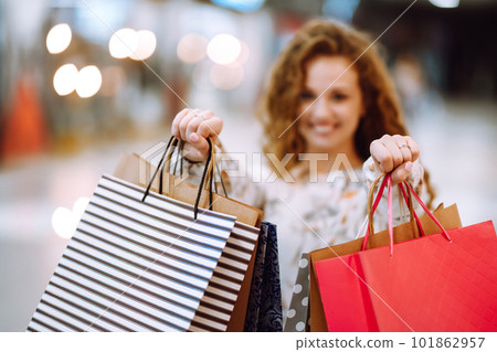 Fashionable woman with multi-colored bags in modern shop center. The joy of consumption. Fashionable woman with multi-colored bags in modern shop center. The joy of consumption. 101862957