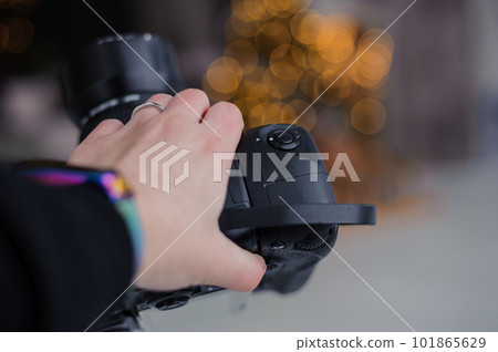 A black camera in the girl's hand, beautiful bokeh behind the background 101865629